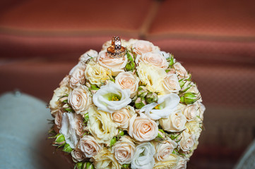 Wedding rings on a bouquet of cream roses
