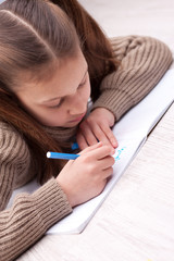 Naklejka premium little girl writing concentrated on her exercise book