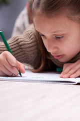 little girl writing concentrated on her exercise book