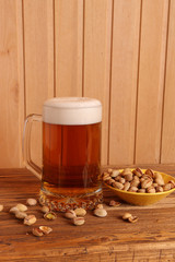 Mug with light beer and pistachios