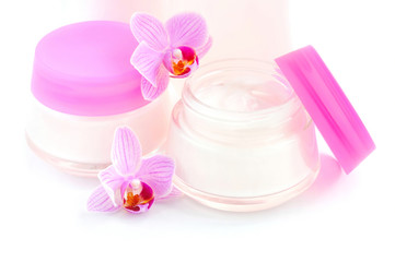 Face creams and beautiful orchid flowers on white background