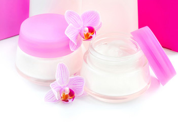 Face creams and beautiful orchid flowers on white background