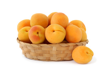 Apricots in wicker dish isolated on white