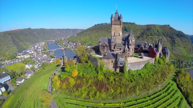 Gorgeous medieval castle aerial shot, vine hills village river