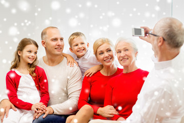 smiling family with camera at home