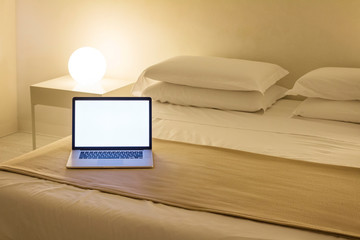 Computer on the bed. hotel bedroom.