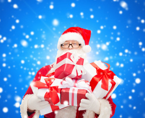 man in costume of santa claus with gift boxes