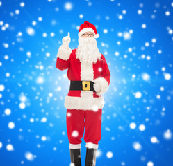 man in costume of santa claus pointing finger up