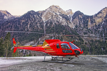 Fototapeta premium Red helicopter in heliport at swiss alps