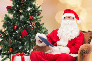 man in costume of santa claus with tablet pc