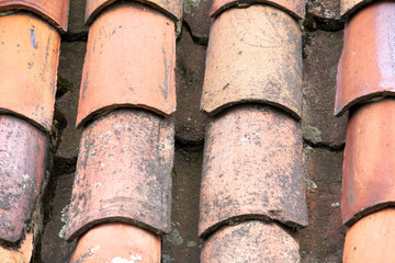 Close up of old and weathered red roof tiles