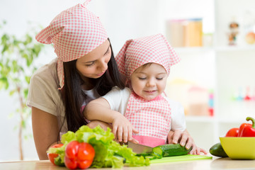 Mother teaches daughter knife cut cucumber