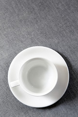 Empty coffee cup on grey fabric