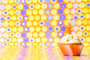 Delicious birthday cupcake on bright background