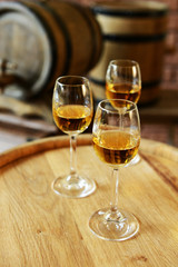 Glasses of wine in cellar with old barrels