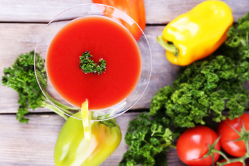 Tomato juice in goblet, pepper, parsley and fresh tomatoes