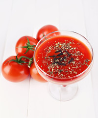 Tomato juice in glass goblet and fresh tomatoes