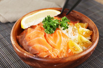 Bowl of boiled rice and fresh salted salmon