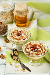 Tasty dessert with oat flakes and honey, on table