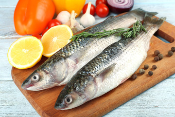 Fresh raw fish and food ingredients on table