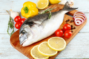 Fresh raw fish and food ingredients on table