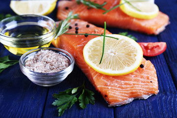 Fresh salmon with spices and lemon on wooden table
