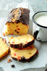 Cake with fruits and chocolate glaze. Mug of fresh milk