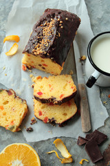 Fruit cake with chocolate glaze and mug of milk