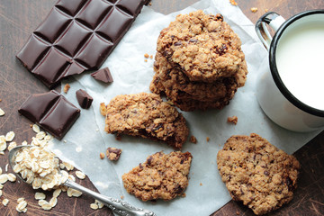 Oat cookies with chocolate and mug of milk