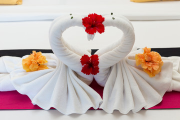 white swans made from towels on bed in the hotel