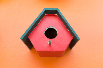colorful bird nest wood box decorated on orange wall background
