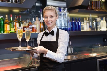 Pretty waitress holding a tray of champagne