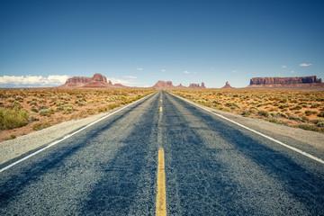 Fototapeta na wymiar Desert highway leading into Monument Valley