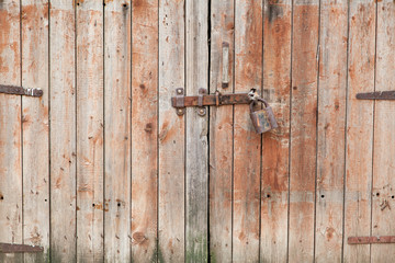Old wooden door locked with padlock