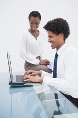Fototapeta na wymiar Smiling designer team using laptop