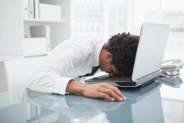 Businessman sleeping on his laptop