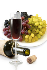 bottle,  glass of wine and a plate with grapes