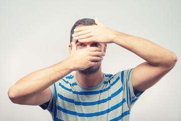 Fototapeta premium Young Caucasian man hiding his face with hand