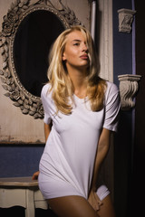 Hot woman in white t-shirt posing in gothic interior