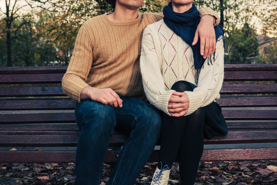 Young couple sitting on park bench