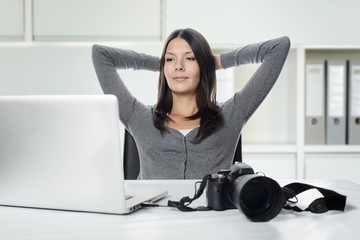 Fotografin lächelt und schaut auf den Laptop Computer