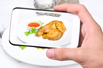 Hands taking photo chicken  with smartphone