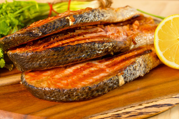 Grilled salmon fillet with lime and parsley on a wooden board