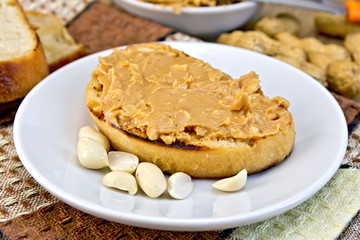 Sandwich with peanut butter and nuts in bowl on napkin