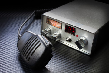 Mike and two way radio that are on and ready to transmit on a carbon fiber surface