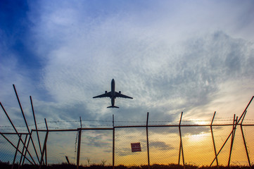 An airplane flying over barbed wire fence in Phuket airport