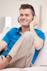 relaxed man listening to music in earphones