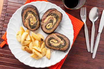 Arrosto farcito con spinaci a fette con patate fritte