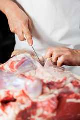 Obraz na płótnie Canvas Midsection Of Butcher Cutting Meat