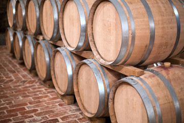 Wine barrels stacked in the old cellar of the winery